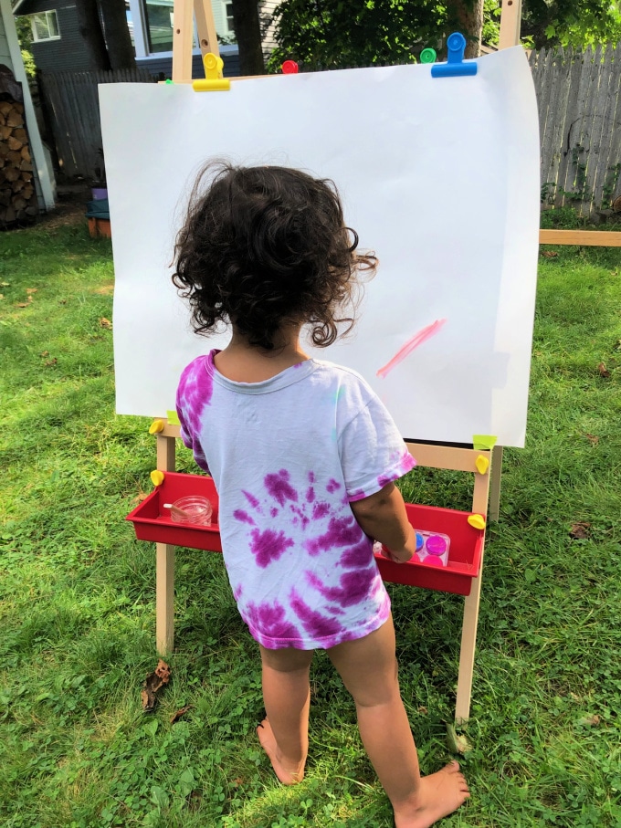 child at an easel outside