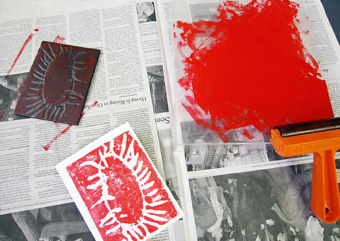 Printmaking supplies: brayer, ink, styrofoam printing plate and printed card.