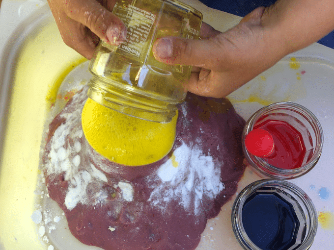 pouring vinegar into baking soda volcano