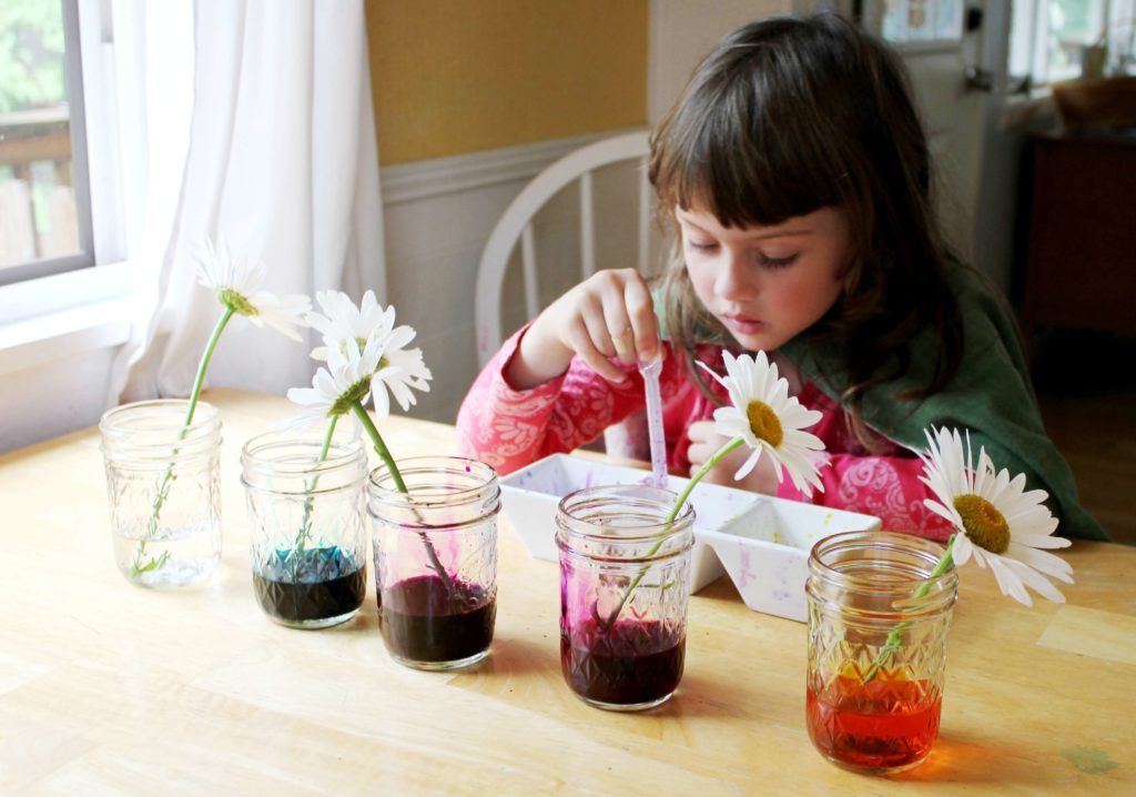 Little girl putting water colors in the container
