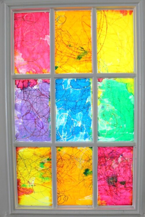 A window with a colorful faux rainbow stained glass made by children.