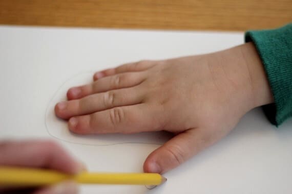 tracing child's hand onto paper