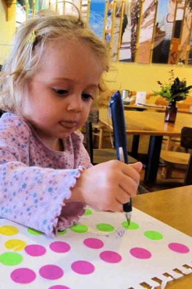Child drawing on dot stickers