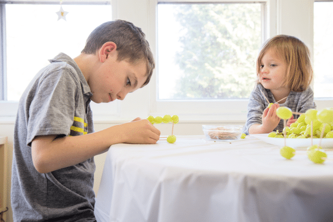 children building with toothpicks and grapes