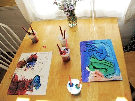 Table with paintings and materials