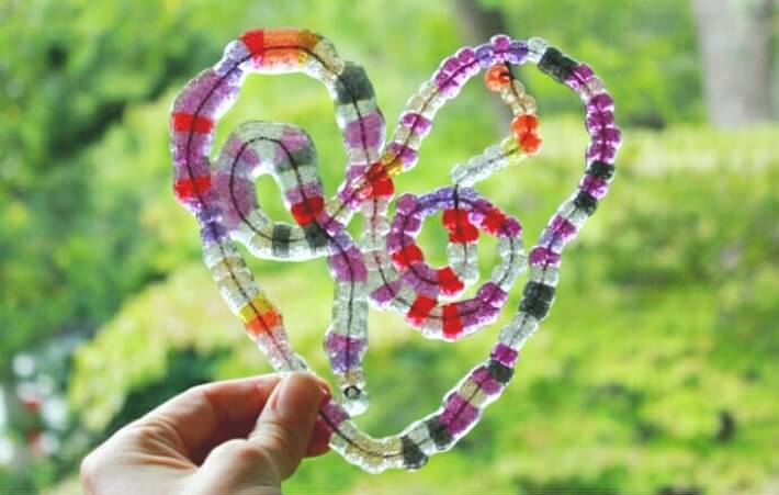 How to Melt Beads to Make Suncatcher Hearts - Holding up a Free Form Heart suncatcher