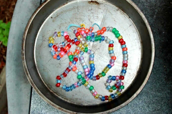 strung pony beads in metal pan ready to be melted into free form artwork