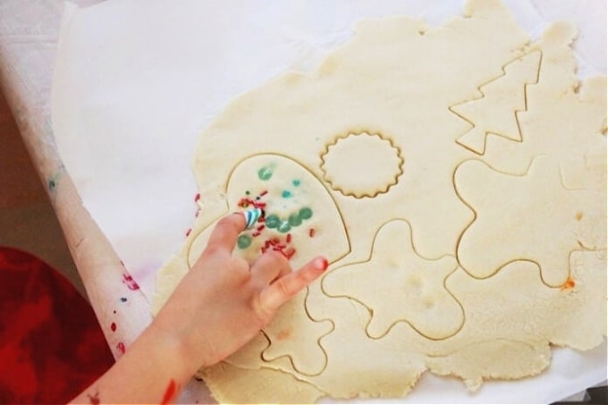 Child pressing beads into salt dough