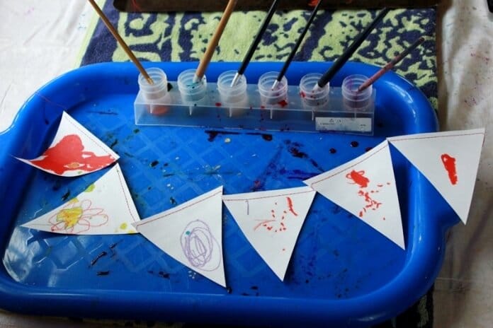 Paper buntings with melted crayon drawings by a child.