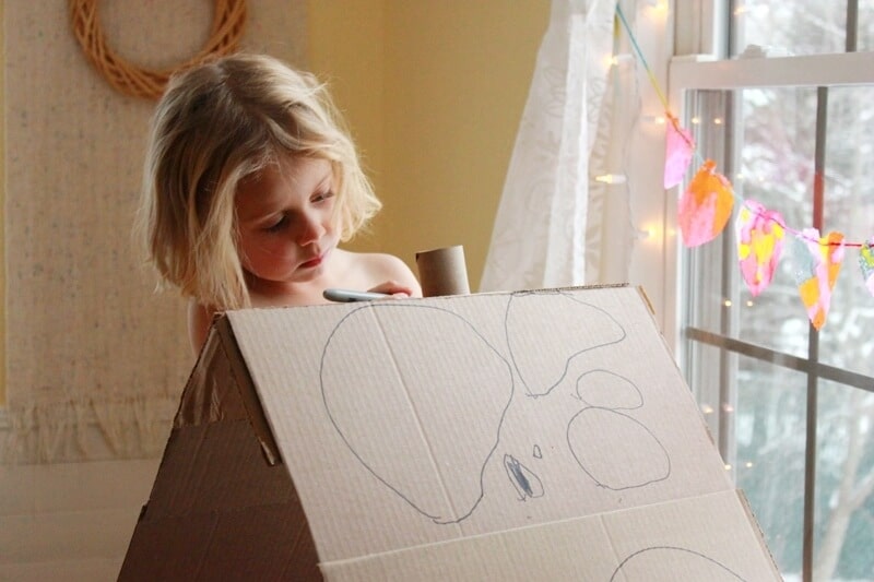 Girl drawing on DIY Cardboard Dollhouse