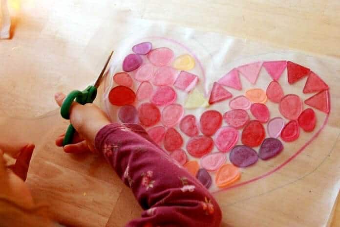 Trimming contact paper on a heart suncatcher