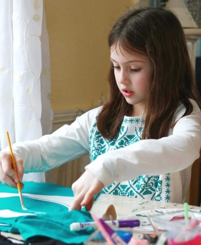 Maia adding Paint brush strokes to her Valentines Day Shirt