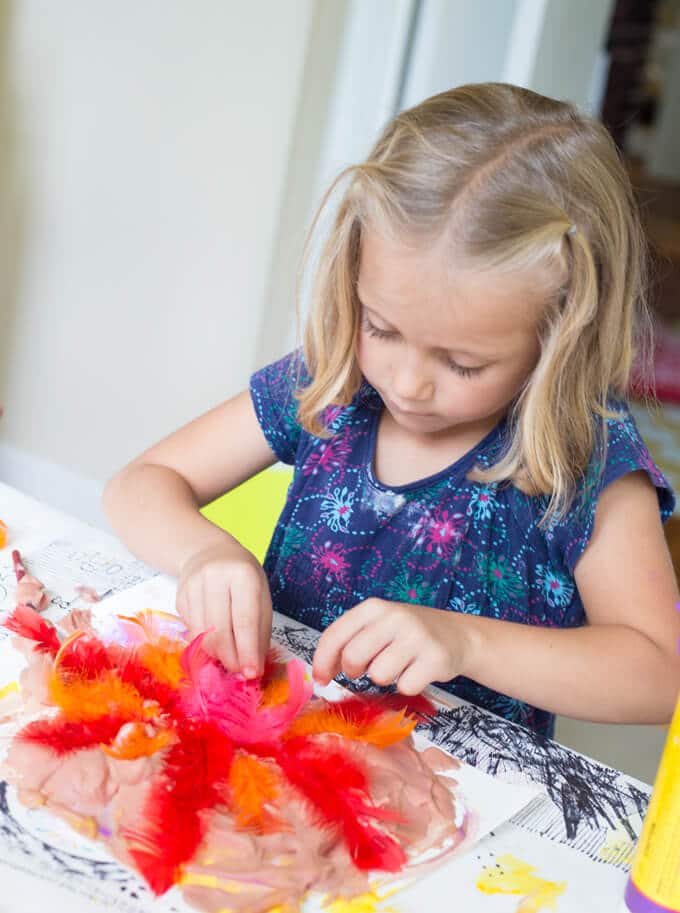 Daphne adding feathers to her foam paint art