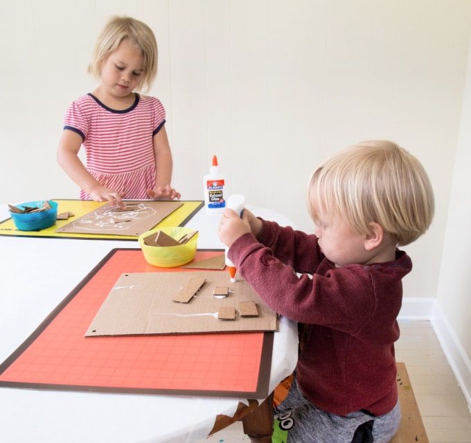 children gluing cardboard