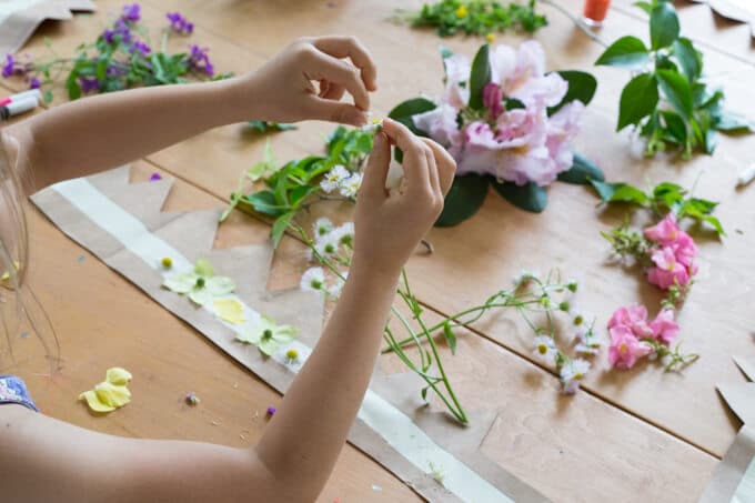 Kids adding Fresh Flowers and flower petals to Sticky Duct Tape to make their own flower crowns.