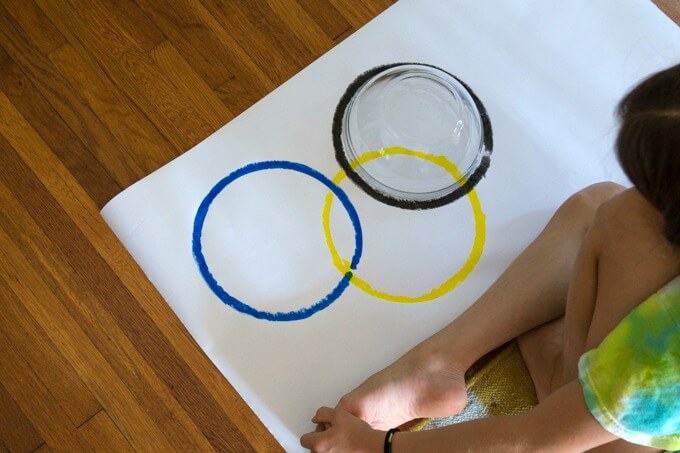 Use a mixing bowl to make the circles on an Olympic Games poster