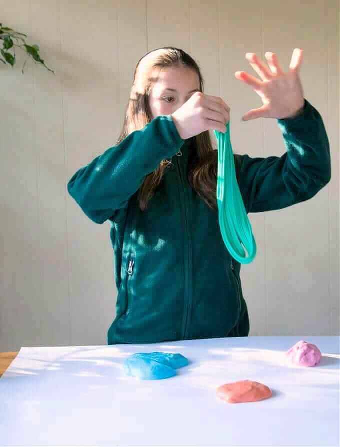 child kneading blue slime