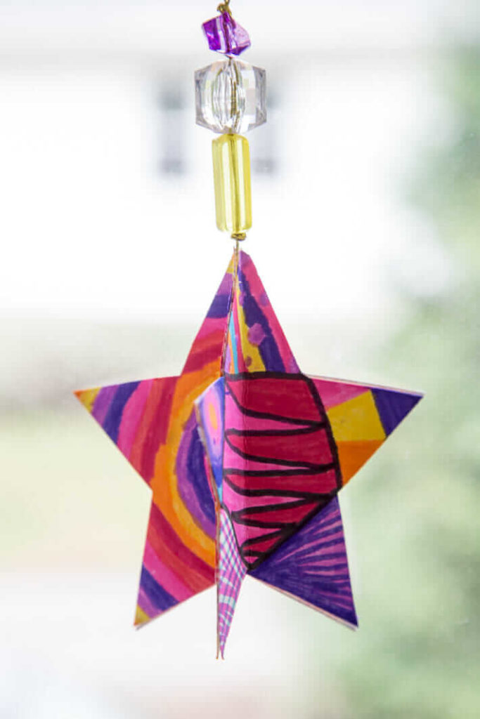 A 3D Paper Star Ornament Hanging in the Window - Easy Christmas Craft
