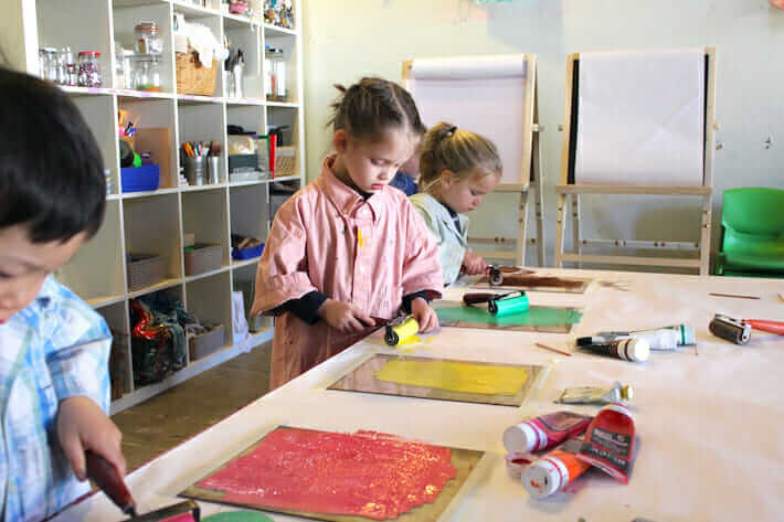 Printmaking for children – inking the plate with a brayer