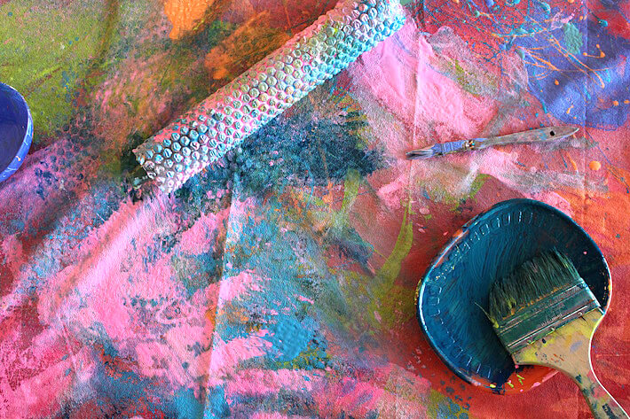 Paintbrushes and bubble wrap rollers for a collaborative mural art project.