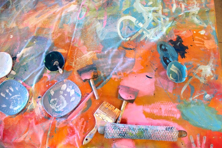 Paintbrushes and bubble wrap rollers for a collaborative mural art project.
