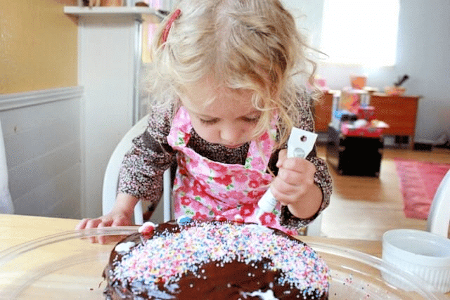 little girl decorating cake