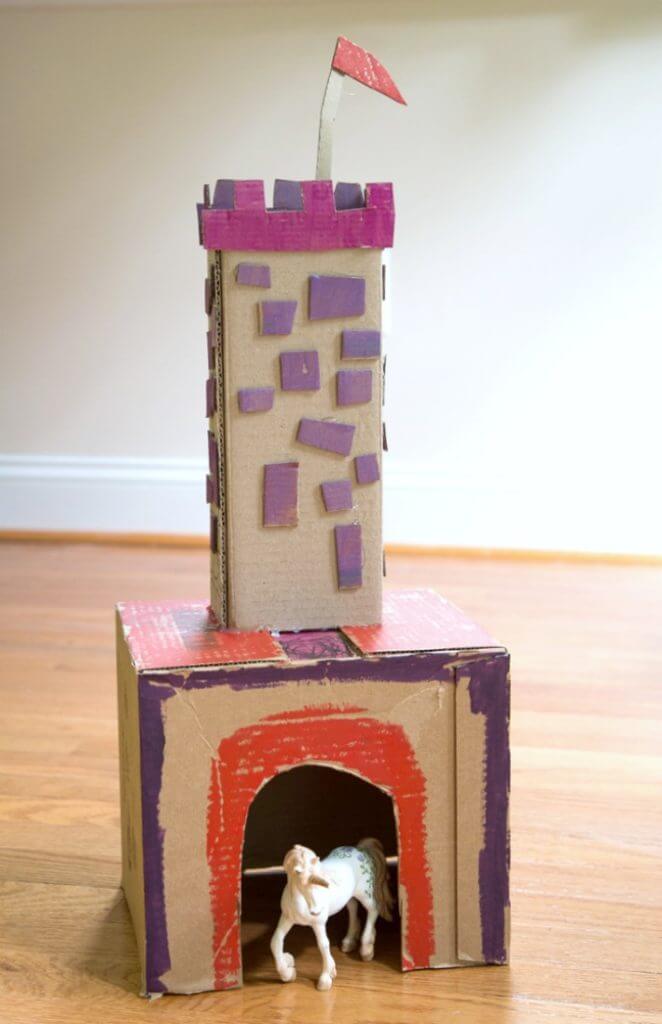Cardboard castle tower with flag, crenelation, and stonework
