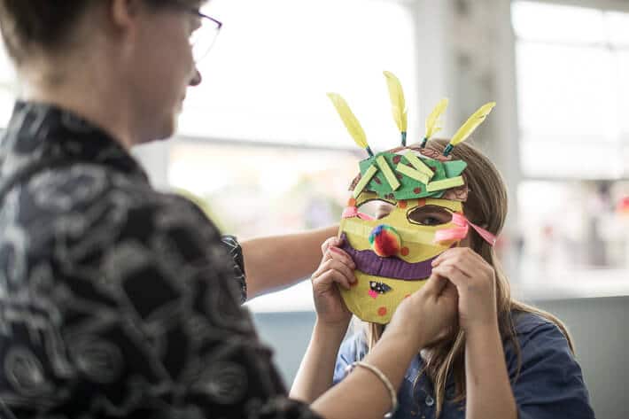 Making Cardboard Masks with Kids - attaching elastic headbands