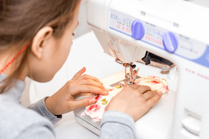 5 Tips for Sewing for Kids – Girl using sewing machine
