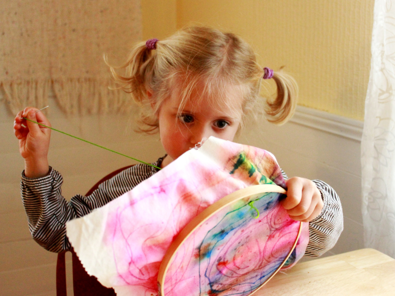 child sewing by hand