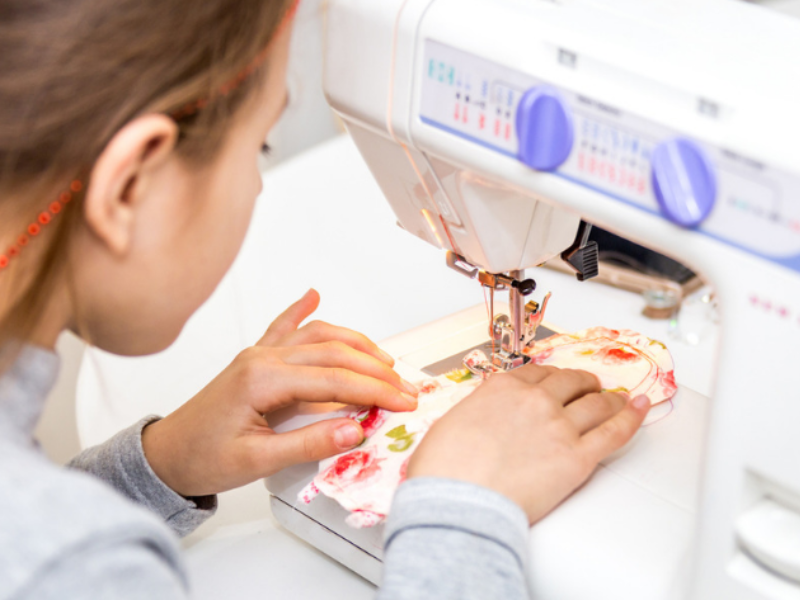 child sewing on machine