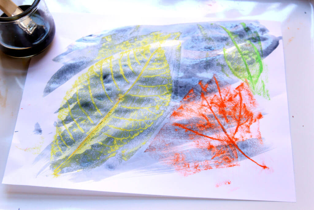 Painting watercolors over crayon leaf rubbings