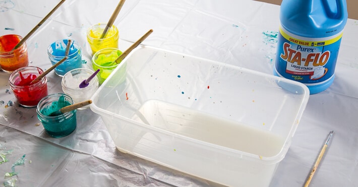 Pour liquid starch into bottom of plastic bin