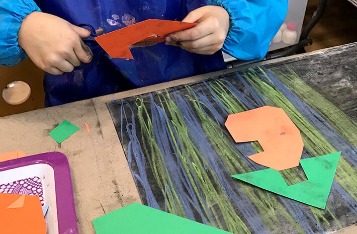 Boy cutting shapes for mixed media cities – Paul Klee Art for Kids
