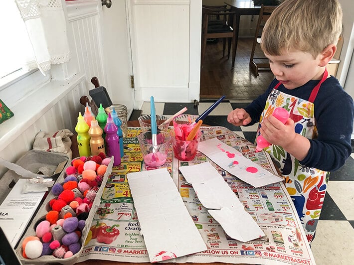 Boy painting cardboard for homemade valentines