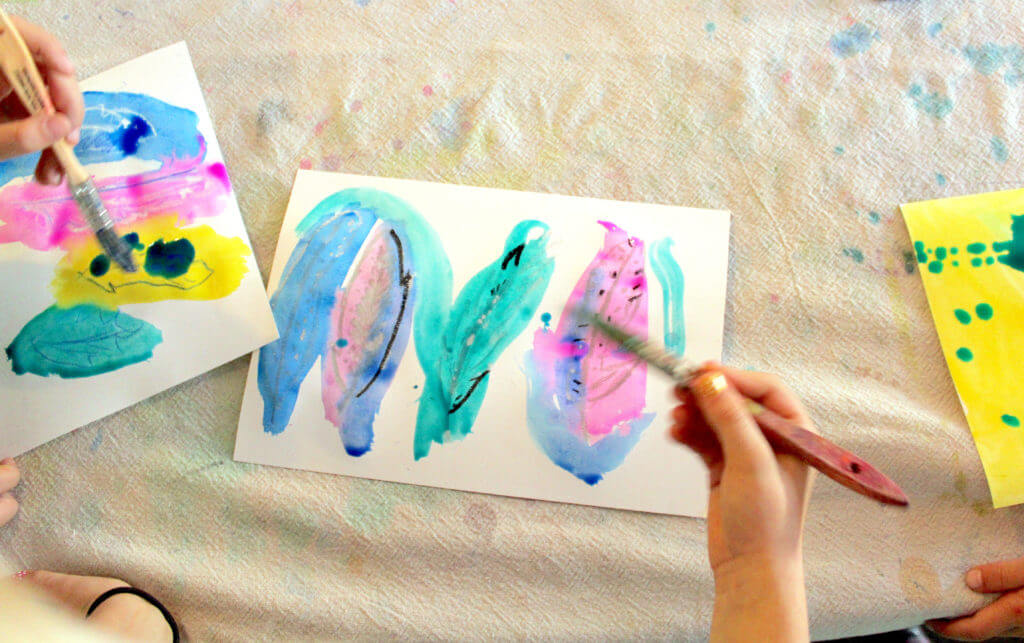 Student painting feathers with a brush in this easy nature art project