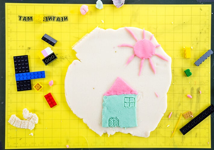 Yellow mat with playdough house & legos for LEGO prints in playdough art activity