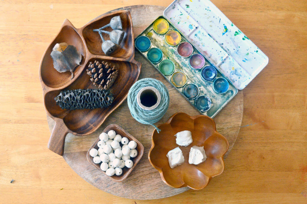 Gathered objects from nature, air dry clay, clay beads, paint and yarn for creating nature mobile