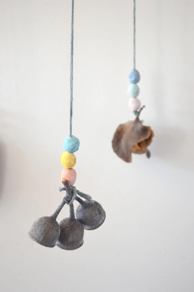 Hanging colored clay beads with nature object attached for nature mobile