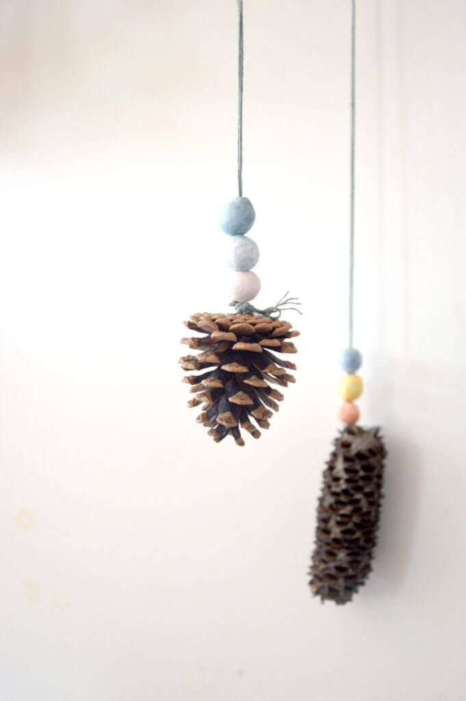 Pine cone and clay beads hanging on cord for nature mobile for kids