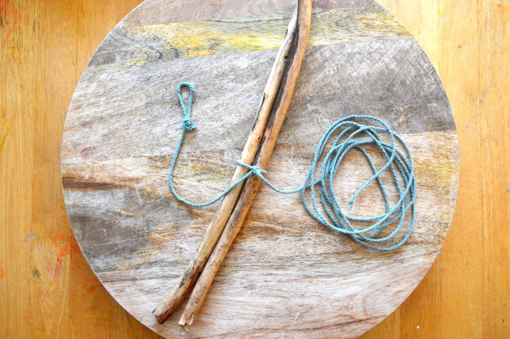 Two sticks with yarn attached for nature mobile