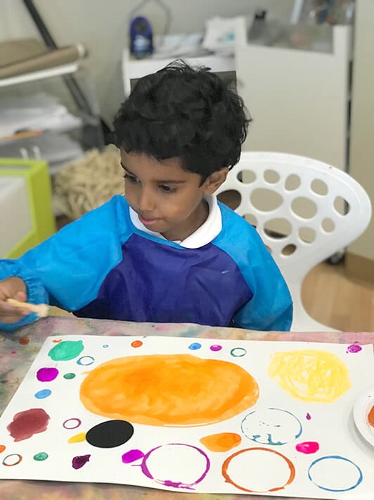 Boy painting Yayoi Kusama Inspired Dot Paintings for Kids