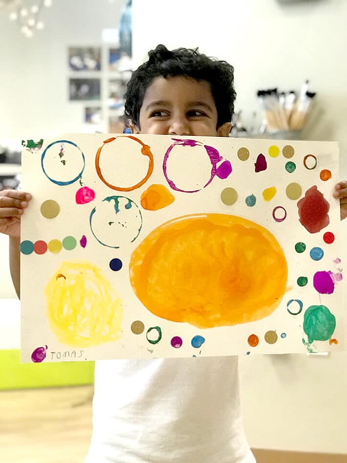 Child holding up Yayoi Kusama Inspired Dot Paintings