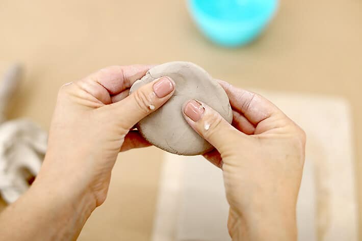 Flattening clay in palms of hand for clay relief tiles