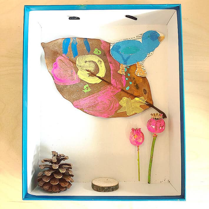 Nature diorama for kids with pinecones, painted leaf, bird and other collected items