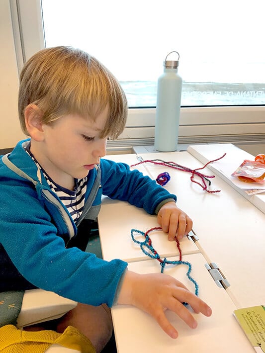 Boy making a train with pipe cleaners