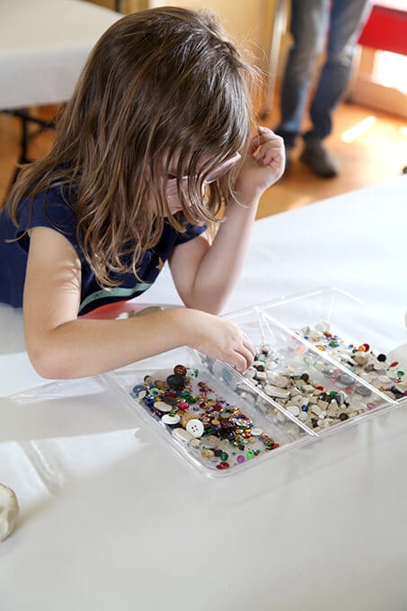 Child choosing materials for mosaic art tiling