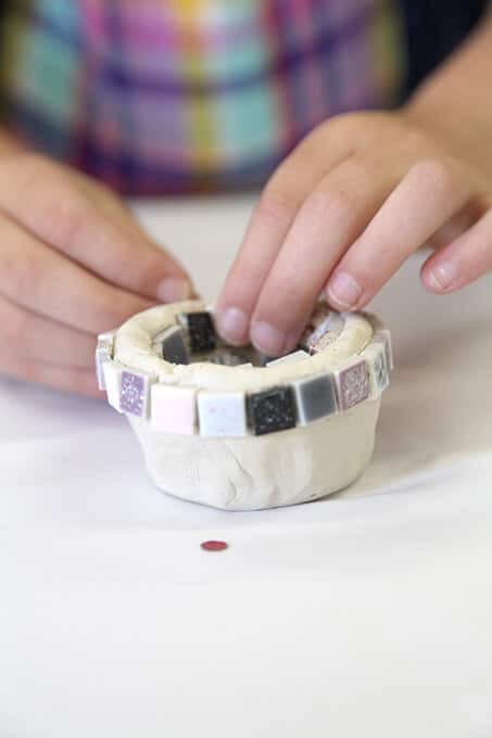 Child creating air dry clay bowl for mosaic art