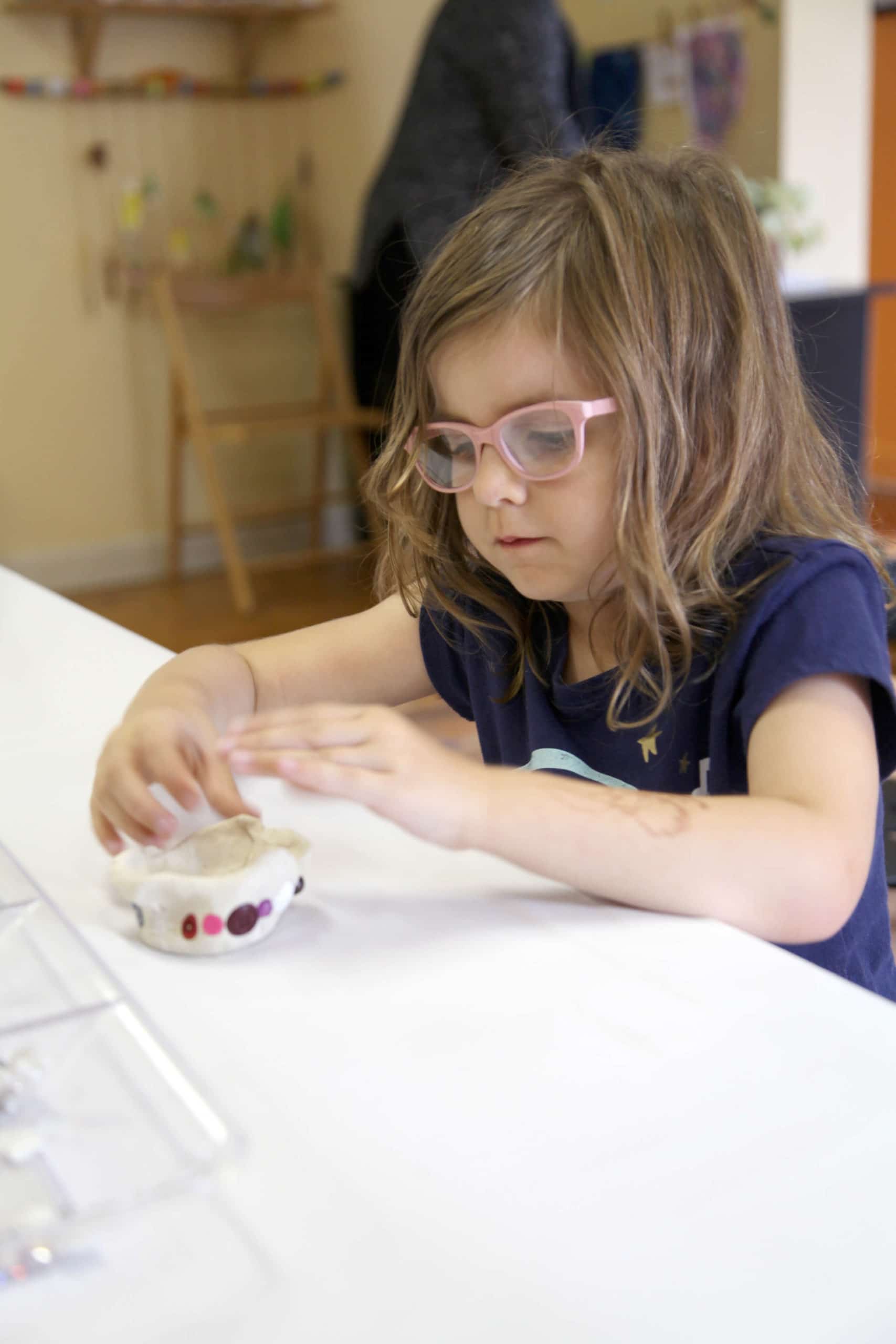 Child creating air dry clay bowl with mosaic tiles