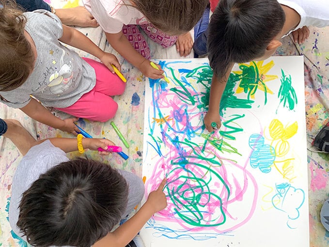 Children paint with tempera sticks on paper